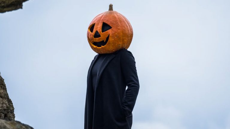 A person in a Halloween pumpkin head costume outdoors in Guasca, Colombia.