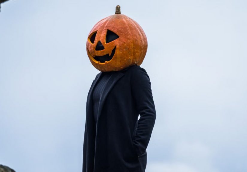 A person in a Halloween pumpkin head costume outdoors in Guasca, Colombia.